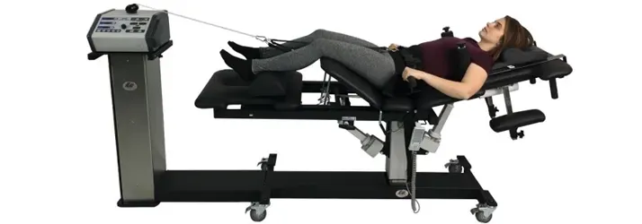 A female patient lying on a spinal decompression table