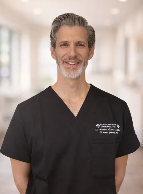 A professional photo of Chiropractor Matthew Amundgaard wearing scrubs